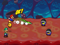 Mario and Luigi battling two Elite Goombules in Trash Pit, under Starlow's guidance