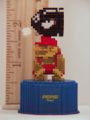 Pixelated figurine of Mario ducking under a Bullet Bill
