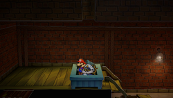 Mario near a Super Mushroom in the garbage bin in Riverside Station of Paper Mario: The Thousand-Year Door for Nintendo Switch.