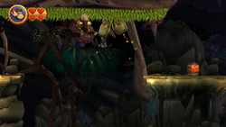 Donkey Kong climbs across a green surface on the ceiling in Grip 'n' Trip in Donkey Kong Country Returns