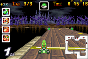 Yoshi racing on the course in Mario Kart: Super Circuit. Note the lack of bouncy pads.