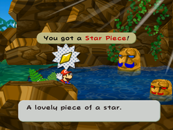 Mario getting the Star Piece  behind the rock before the red and blue Mario-like stones and on the south side of the scene before the Pirate's Grotto in Paper Mario: The Thousand-Year Door.