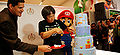 Shigeru Miyamoto cutting the Super Mario Bros.-themed cake at the 25th Anniversary event.