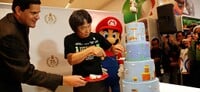 Shigeru Miyamoto and Reggie Fils-Aime cutting a Super Mario Bros. 25th Anniversary cake