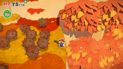 Mario standing near a hole containing a group of coins in Chestnut Valley of The Origami King.