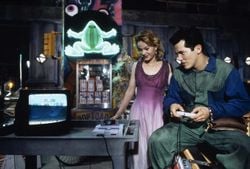 John Leguizamo plays Super Mario World as Samantha Mathis watches.