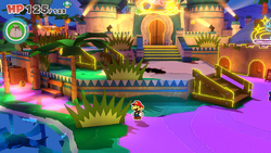 Mario standing near a bush with a coin behind it in Shroom City of The Origami King.