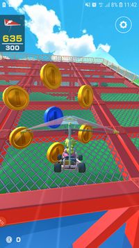 Peach approaching a Blue Coin surrounded by regular Coins during the Glider Challenge in Mario Kart Tour