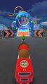 Luigi and Monty Mole approaching the blue circus cannon on Singapore Speedway R in Mario Kart Tour