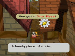 Mario getting the Star Piece on the crate behind the left walls in east Rogueport in Paper Mario: The Thousand-Year Door.