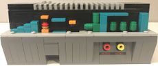 The LEGO Super Mario Nintendo Entertainment System's panel comes off to reveal a recreation of World 1-2.