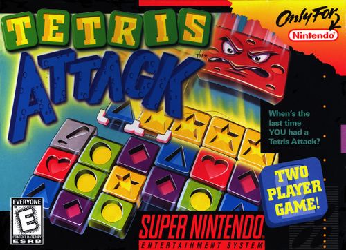 The North American SNES boxart for Tetris Attack. In the upper left, "Tetris" is spelled out in yellow lettering on green panels, while "Attack" is written underneath in blue lettering. The bottom left has an ERSB "E" rating, with the bottom right has the Super Nintendo Entertainment System logo and the words "Two Player Game!" in yellow lettering on a blue panel. The upper right corner has "only for Nintendo" written on an orange background. The bulk of the box is devoted to the central artwork, which shows the various panels which appear in the game falling together. An angry red block with a face is about to fall onto the rest of the panels.